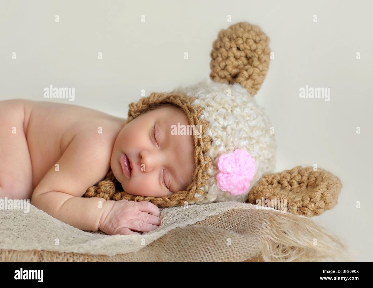 Neonato femmina che dorme con un grazioso cappello a forma di animale Foto Stock