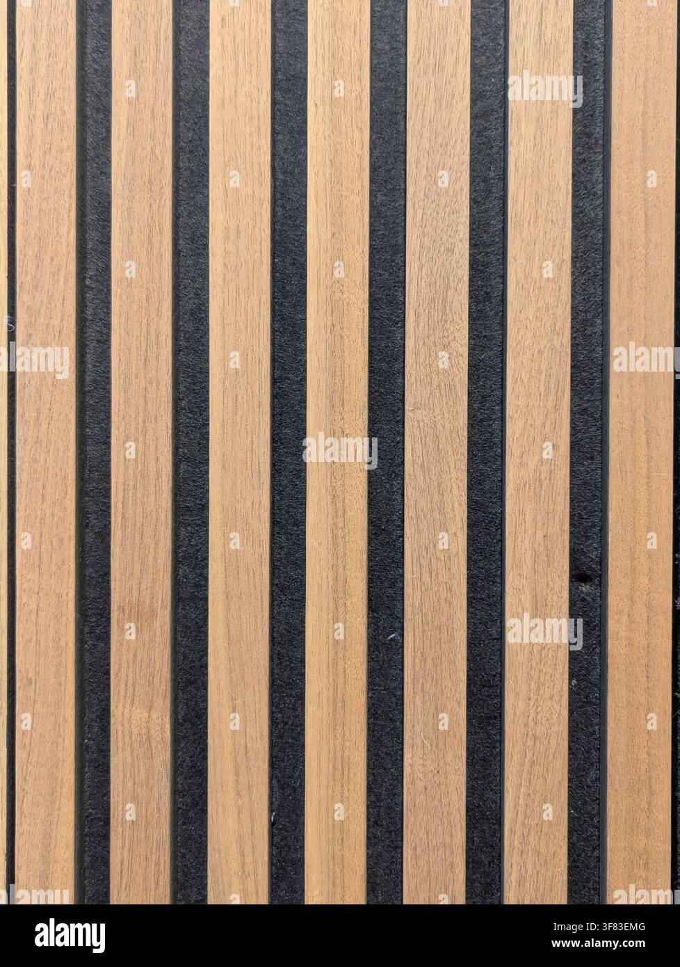 una vista ravvicinata di listelli di legno con strisce di gomma nera, inseriti in un ambiente neutro, forse all'aperto o in uno spazio industriale, offrendo una pulita Foto Stock