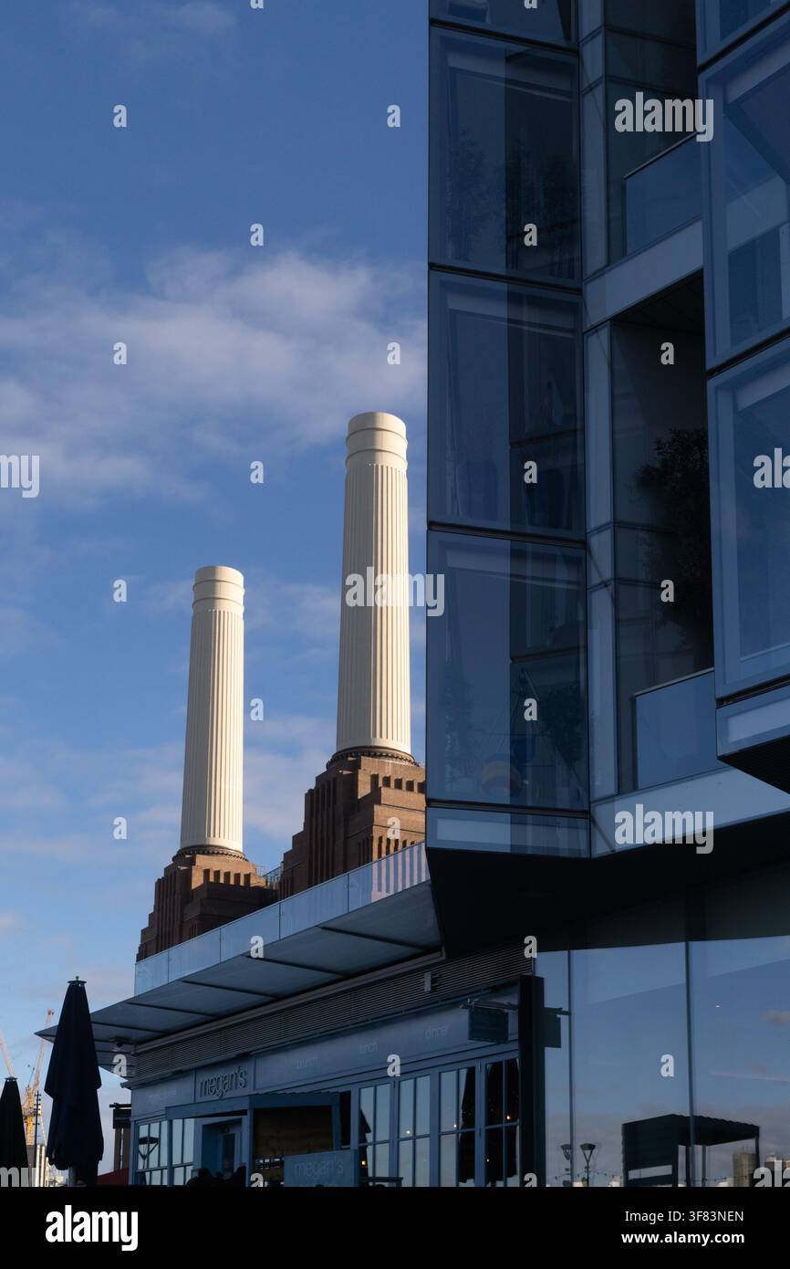 I visitatori cenano alla Battersea Power Station di Londra, dove le iconiche ciminiere evidenziano la transizione del sito in un moderno hub di stile di vita. Foto Stock