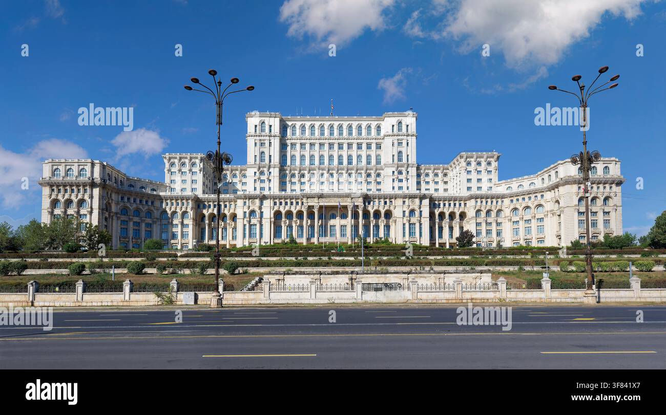 Palazzo del Parlamento a Bucarest con cielo azzurro e spazi verdi visibili davanti Foto Stock