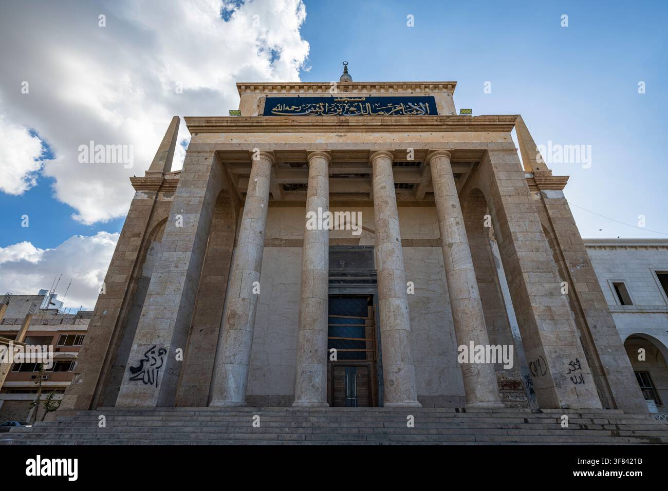 Struttura monumentale si erge in modo prominente con colonne imponenti e iscrizioni arabe nella storica regione di Bengasi in Libia Foto Stock