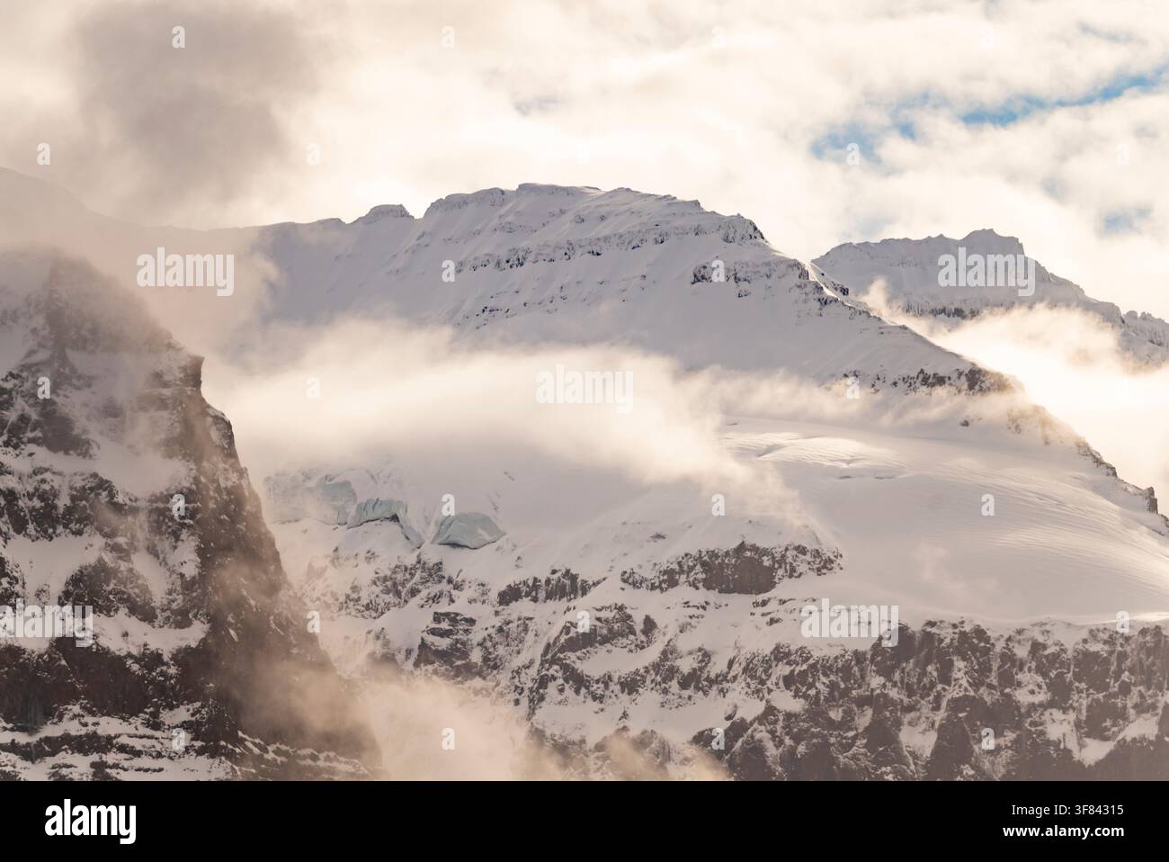 Dettagli ravvicinati di creste ghiacciate e nebbia che rivelano le texture di neve e roccia nelle alte vette vicino a Borgvig in Groenlandia Foto Stock