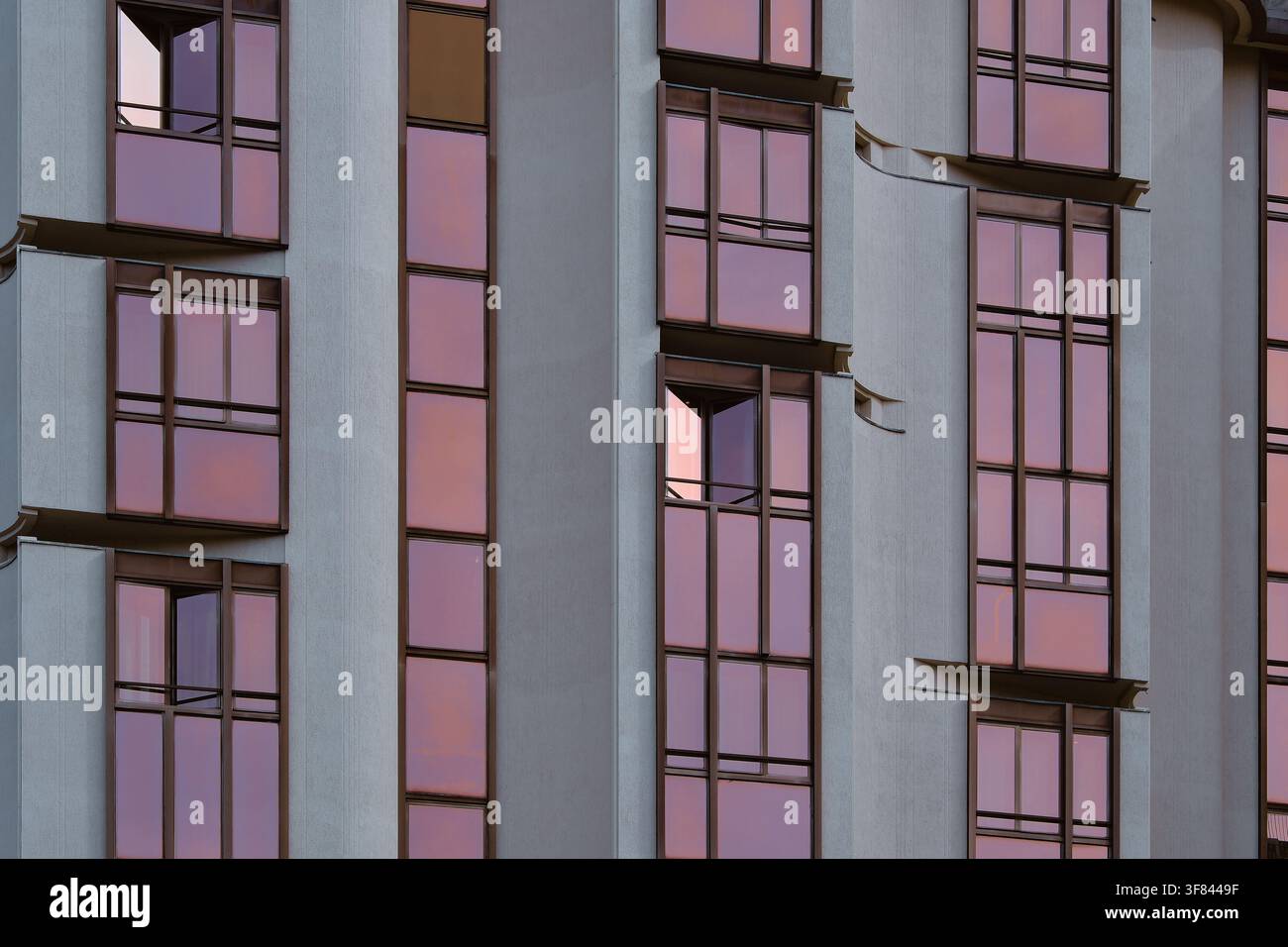 Dettaglio architettonico ravvicinato di alte finestre rosa su un edificio contemporaneo a Firenze, Toscana, Italia. Foto Stock