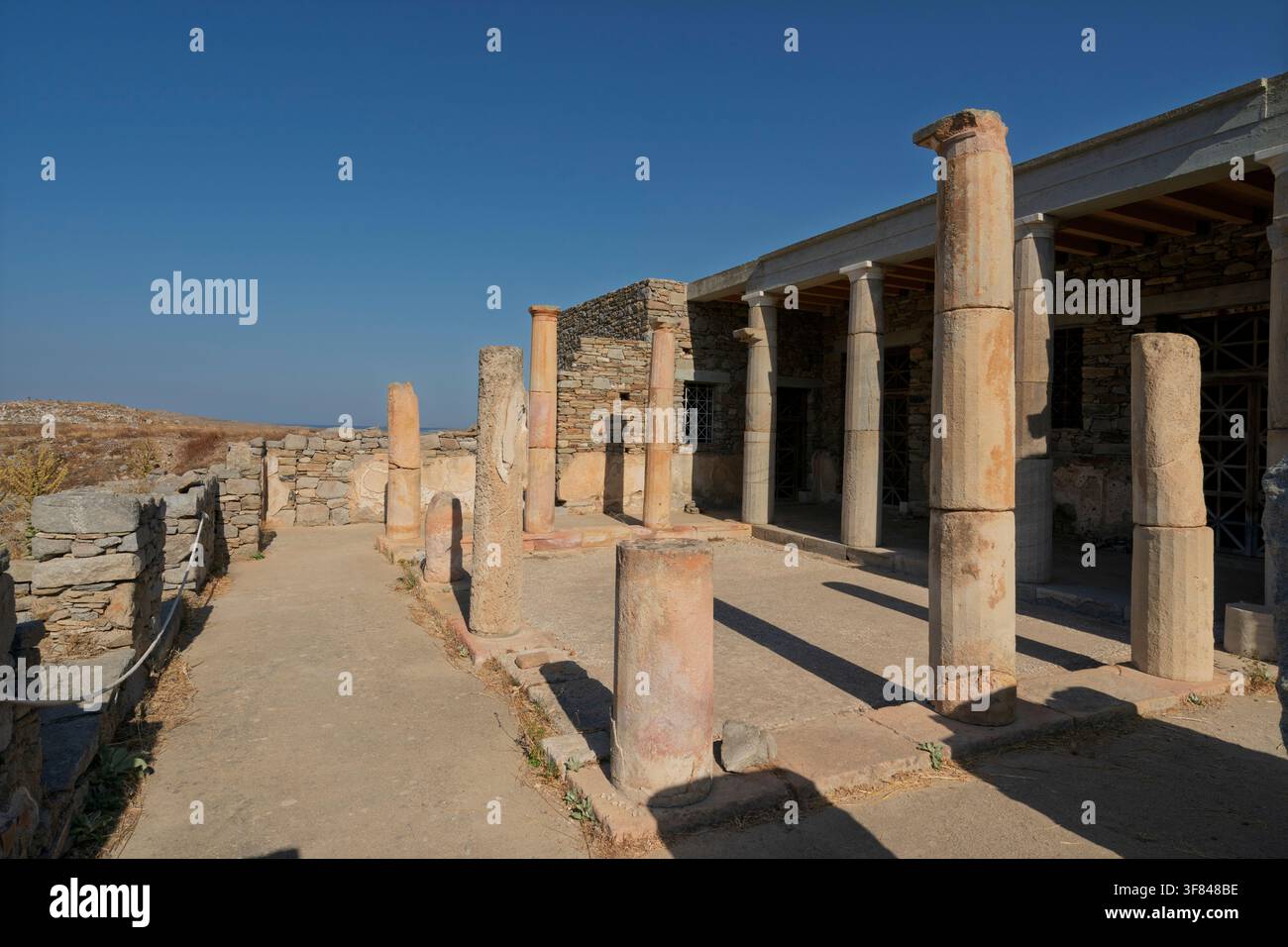 Esplorazione delle rovine storiche della Casa della Maschera nel sito archeologico di Delo in Grecia Foto Stock