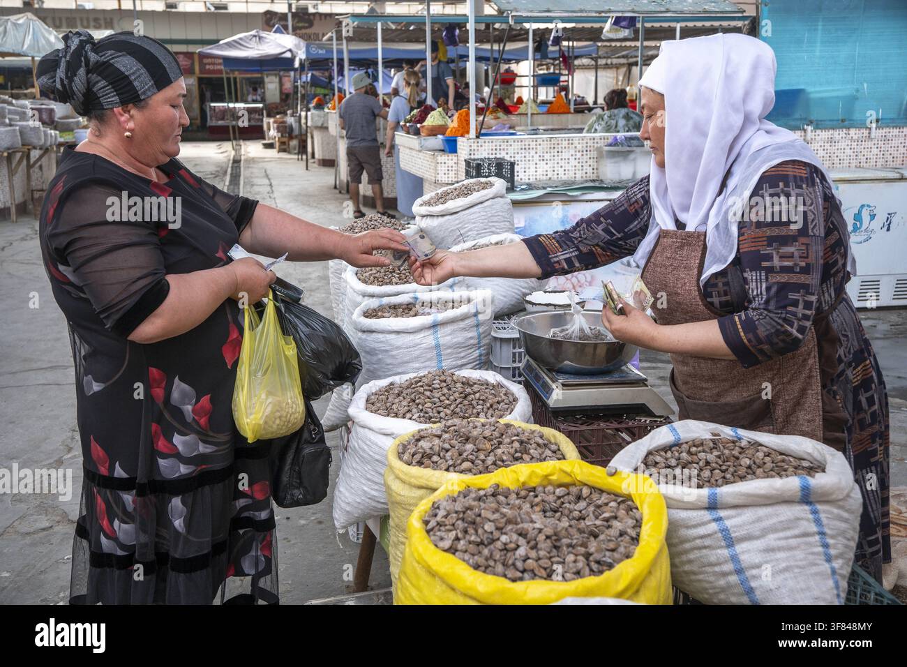 Scena vivace di un mercato alimentare dove i venditori vendono noci e frutta secca a Bukhara, Uzbekistan, durante il giorno Foto Stock