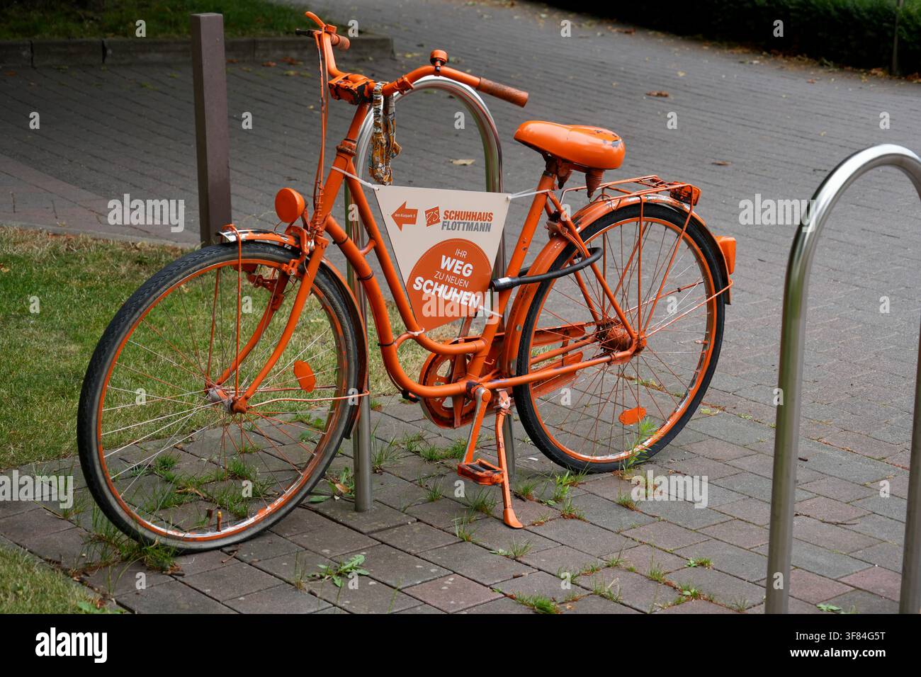 Bicicletta classica in stile olandese dipinta di arancione che pubblicizza Flottmann Shoe Store. Foto Stock