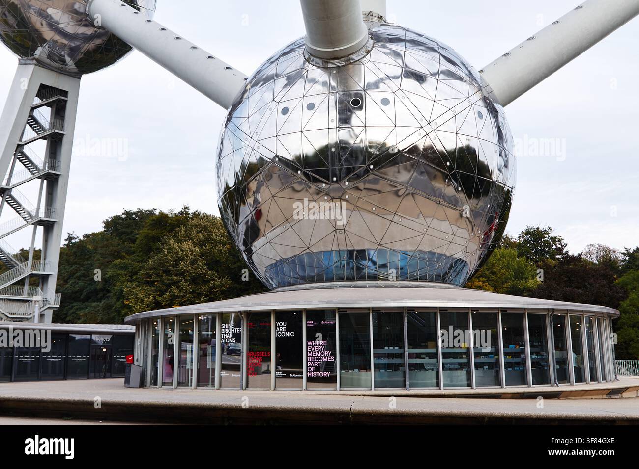 Bruxelles, Belgio-1 ottobre 2025: L'Atomium di Bruxelles presenta grandi sfere riflettenti e un padiglione di vetro alla sua base, circondato da una vegetazione rigogliosa Foto Stock