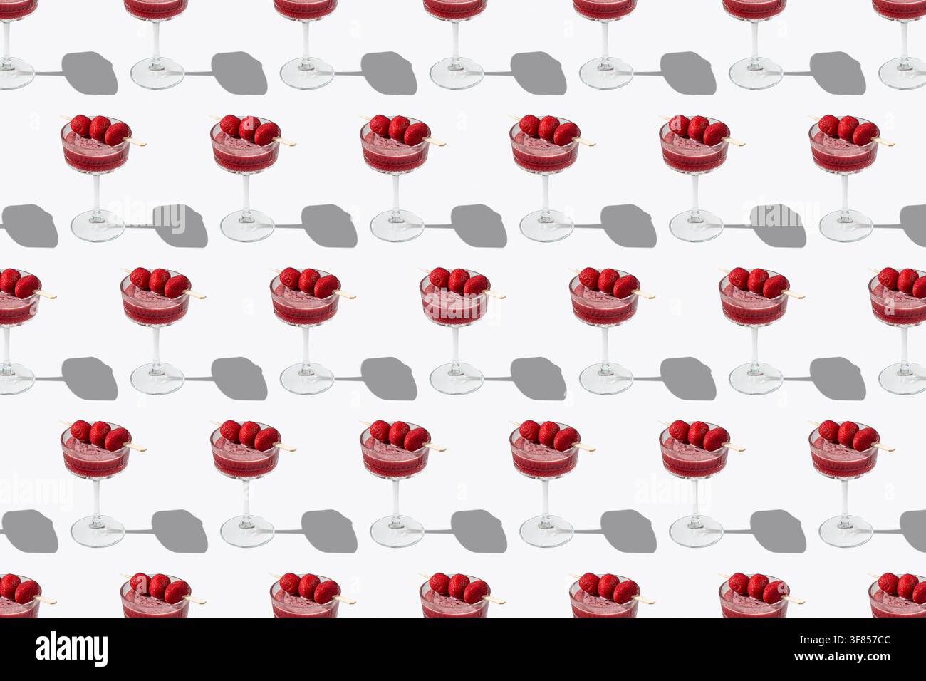 Cocktail di fragola con guarnizione di bacche fresche in schema ripetuto su sfondo bianco Foto Stock