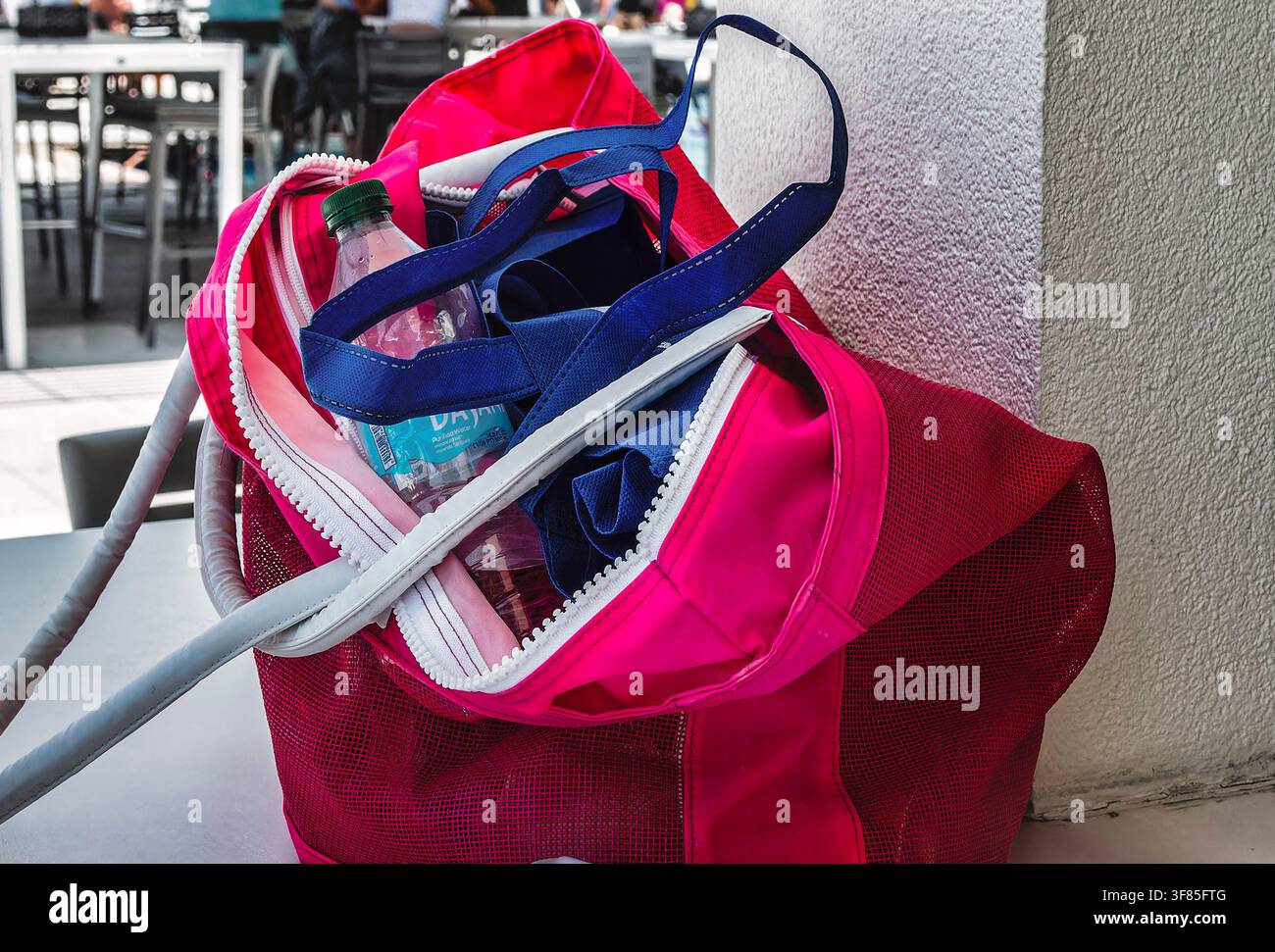 Questa vivace borsa rosa e rossa presenta un ampio compartimento principale con una chiusura a cerniera sicura Foto Stock