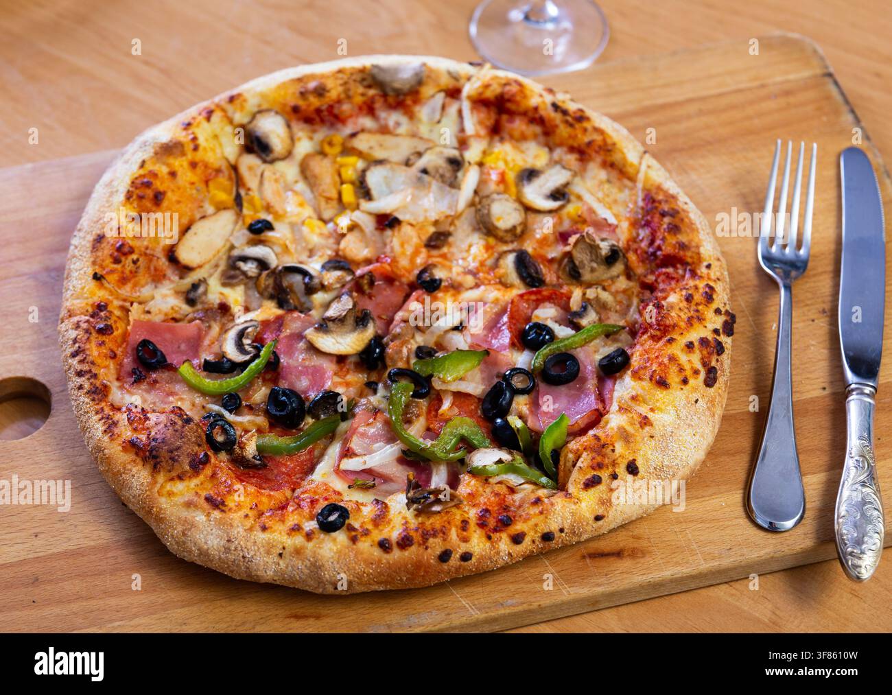 Pizza doppia servita su tavola di legno Foto Stock