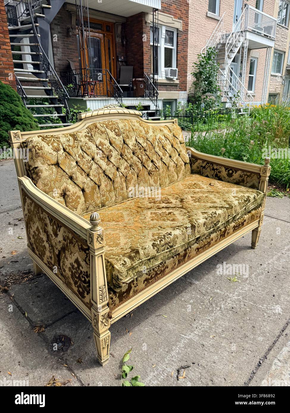 Un divano vintage abbandonato su un marciapiede a Montréal, Quebec, Canada. Foto Stock