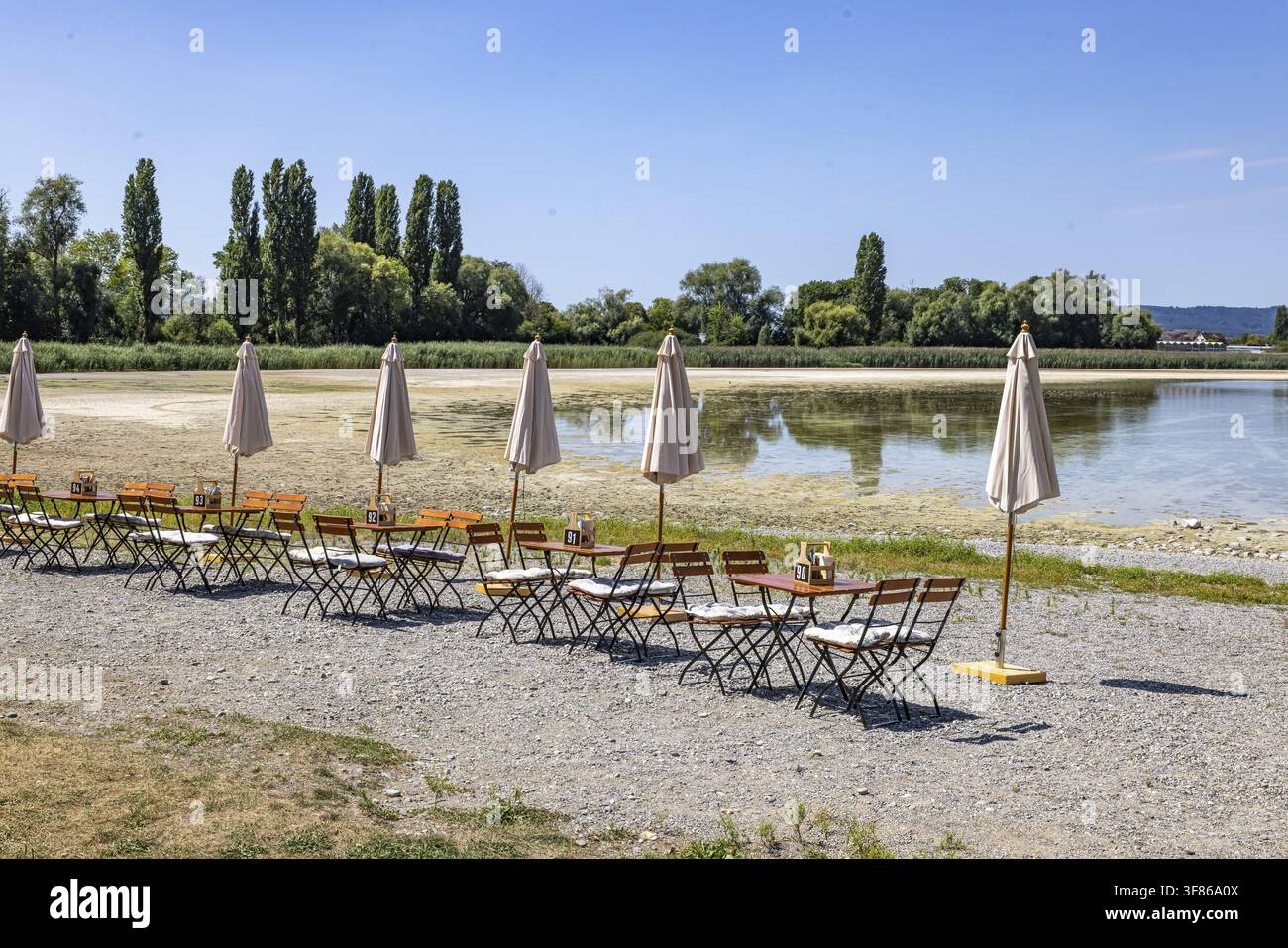 Spiaggia sull'isola di Reichenau nel lago di Costanza. Sull'riva ci sono tavoli e sedie per la gastronomia del lido. Reichenau, Baden-Wuerttemberg, Germania Foto Stock