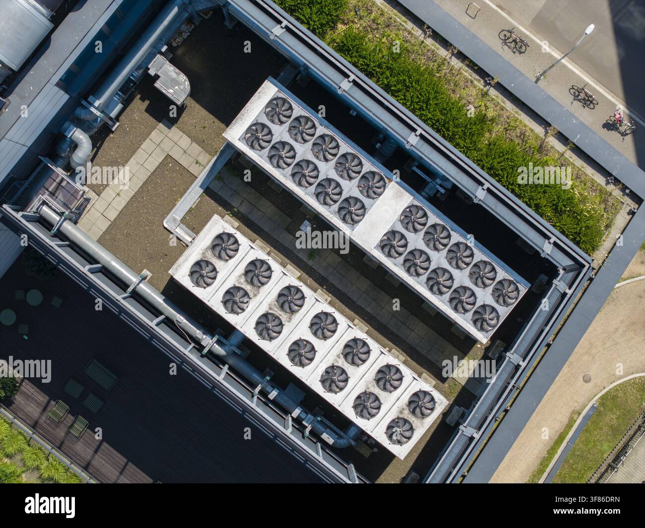 Vista aerea del tetto di un centro dati AI con file di ventole di raffreddamento industriali e sistemi di ventilazione su un edificio moderno a Cracovia, Piccola Polonia Foto Stock