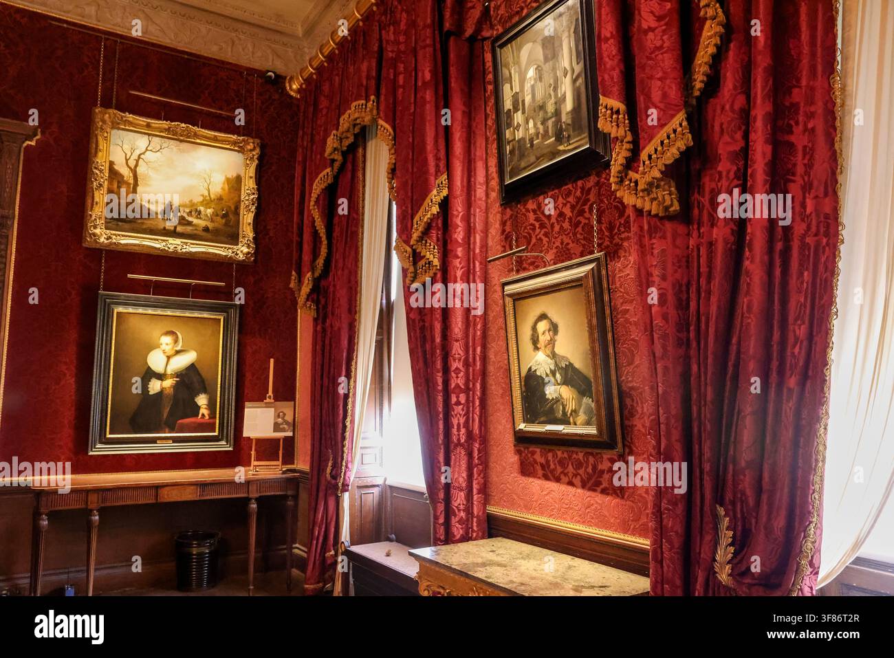 Dipinti del lascito Iveagh esposti su pareti di damasco rosso all'interno del Kenwood House, Hampstead Heath, Londra. Foto Stock