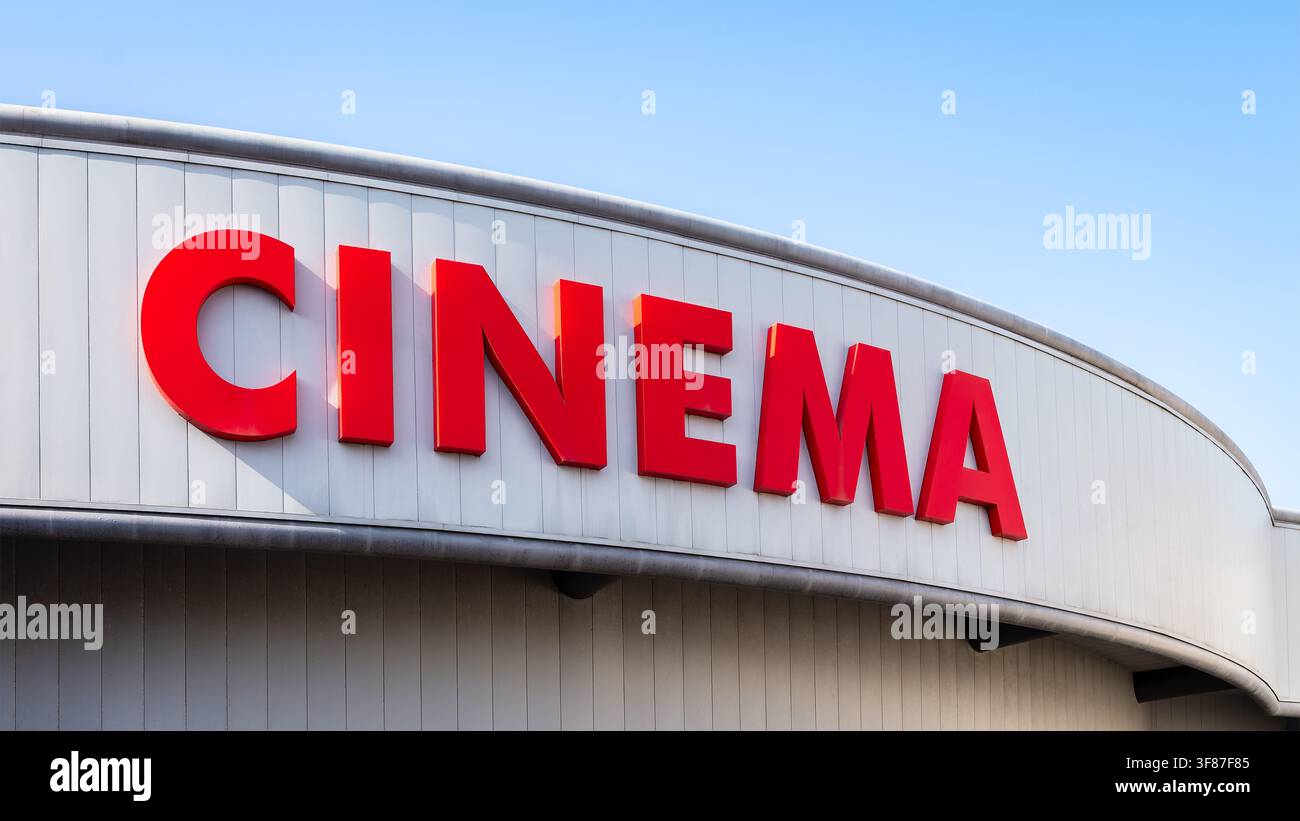 Primo piano del grande cartello "cinema" di un cinema in lettere maiuscole rosse in una giornata di sole Foto Stock