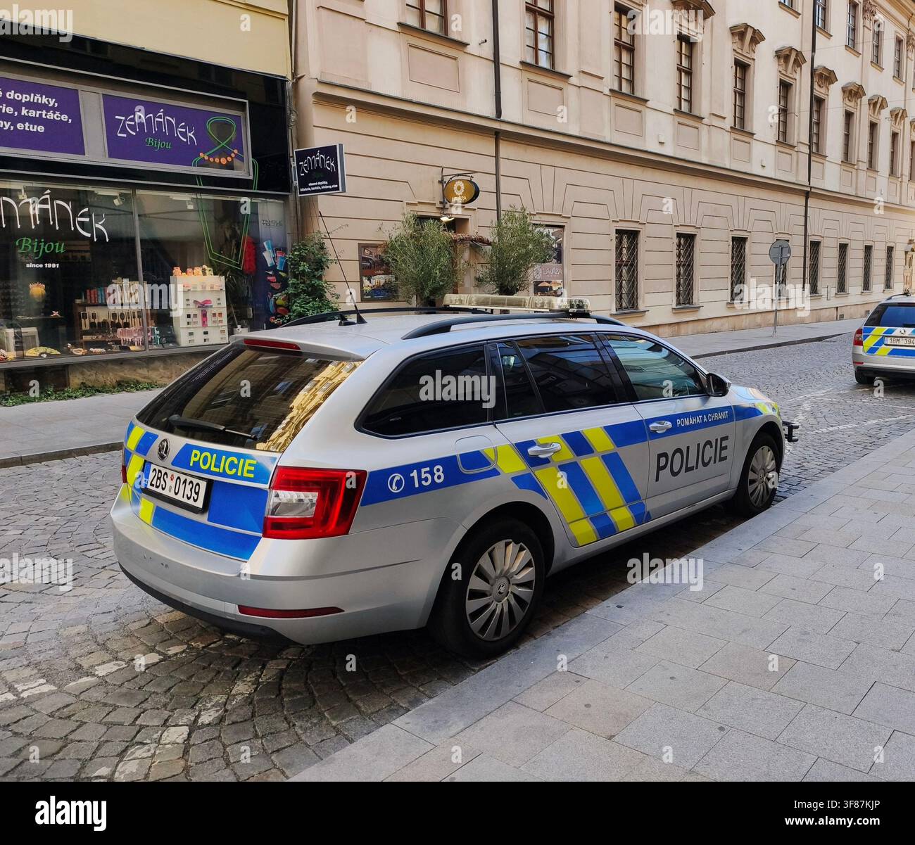 Auto della polizia ceca Skoda Octavia parcheggiata su una strada acciottolata nel centro storico della città di Brno - Immagine stock catturata con smartphone