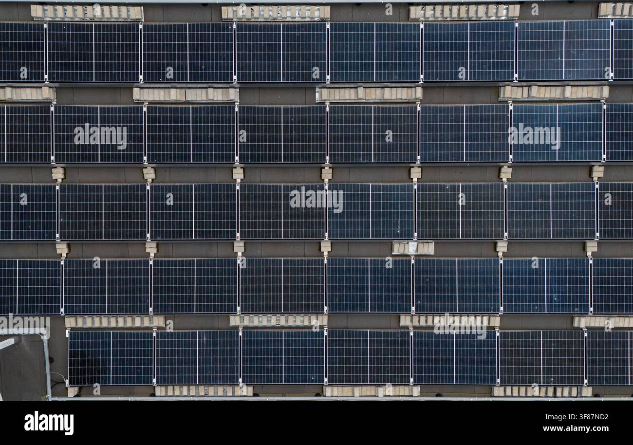 Vista aerea ravvicinata di un array di pannelli solari montati a file su un tetto commerciale piatto, concetto di dettaglio di installazione di energia rinnovabile e fotovoltaica. Foto Stock