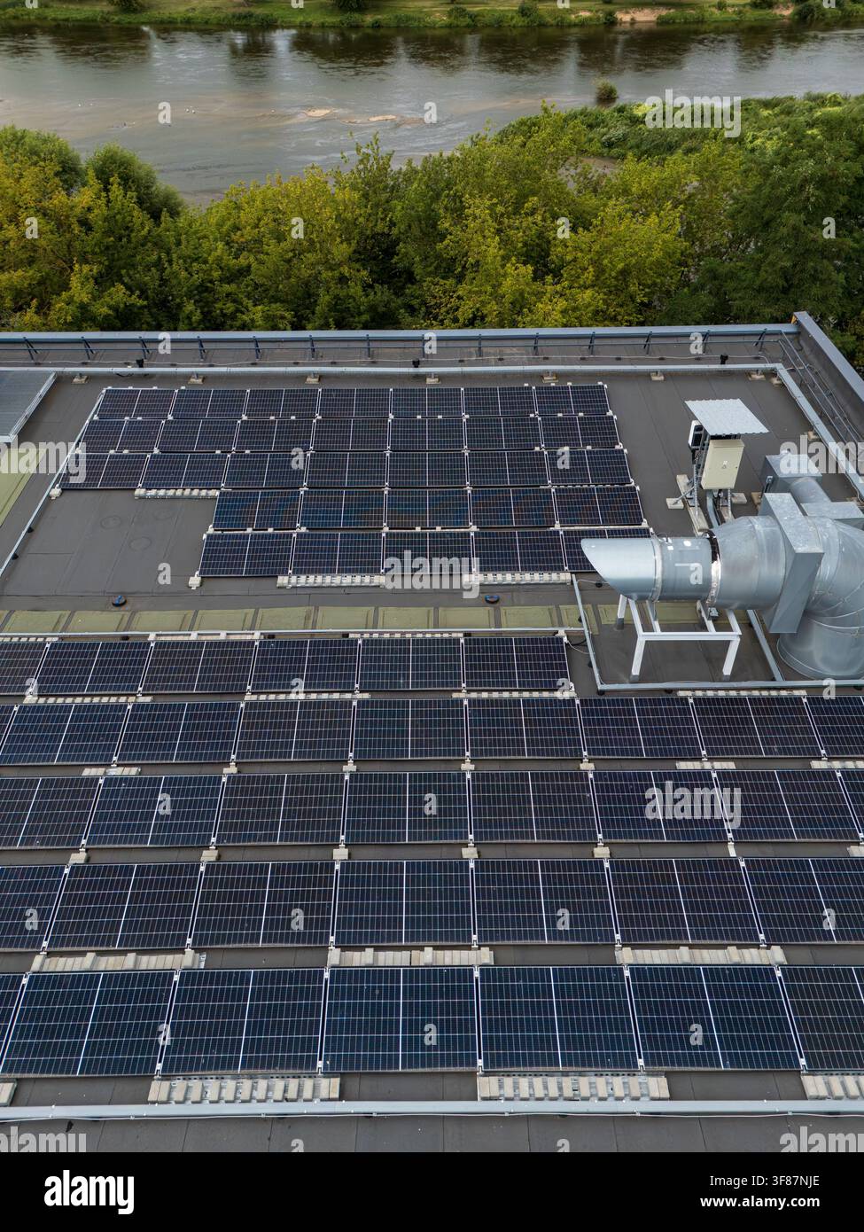 Vista aerea ravvicinata di un array di pannelli solari montati a file su un tetto commerciale piatto, concetto di dettaglio di installazione di energia rinnovabile e fotovoltaica. Foto Stock