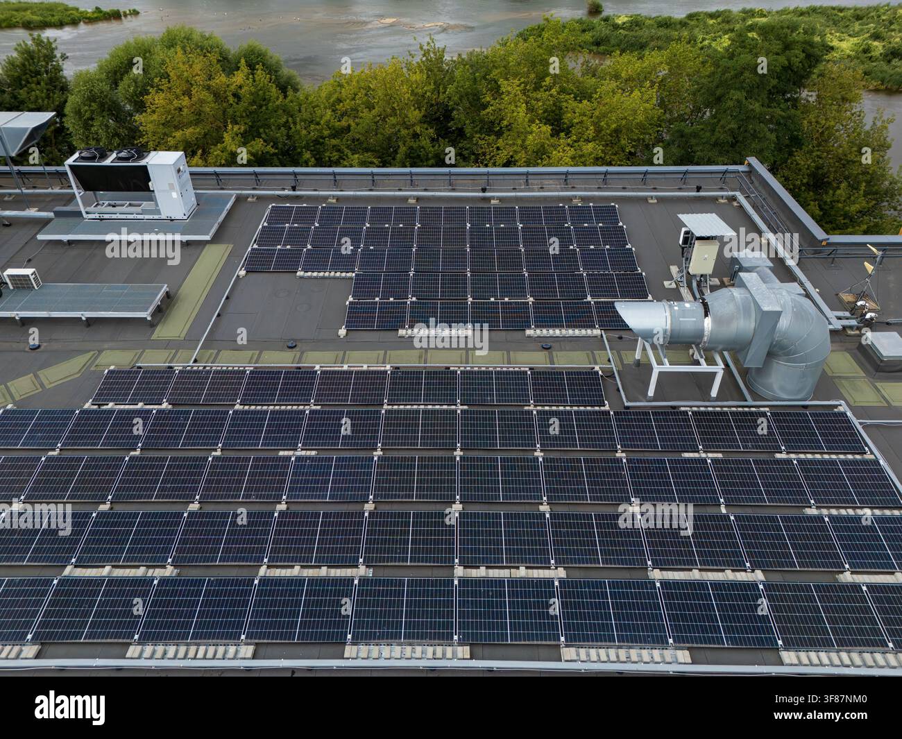 Vista aerea di un array di pannelli solari montati a file su un tetto commerciale piatto, concetto dettagliato di energia rinnovabile e installazione fotovoltaica. Foto Stock
