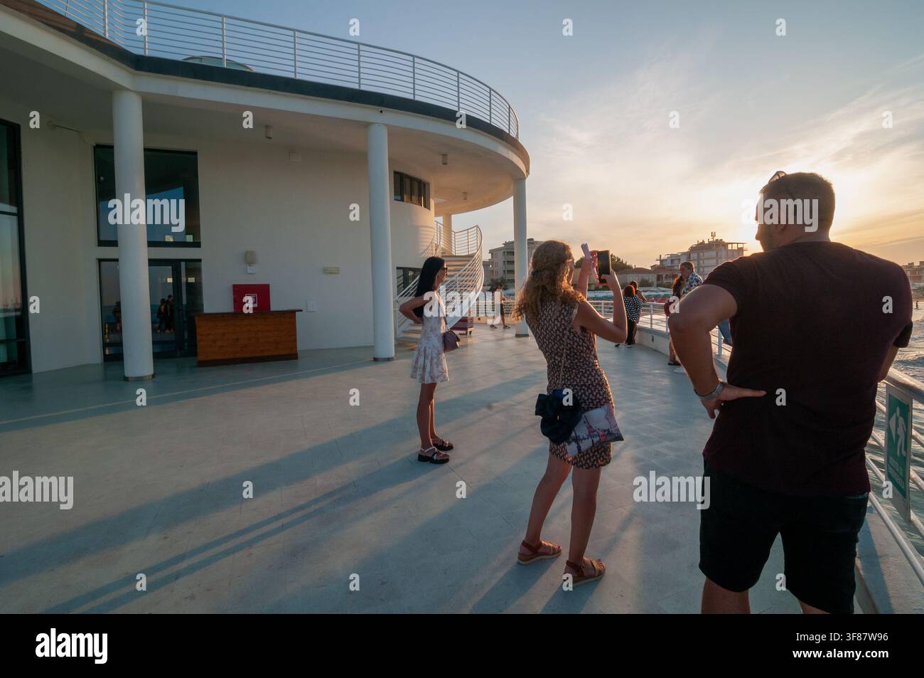 Senigallia: Vista della Rotonda a Mare. Turisti che scattano foto al tramonto. Italia. Foto Stock