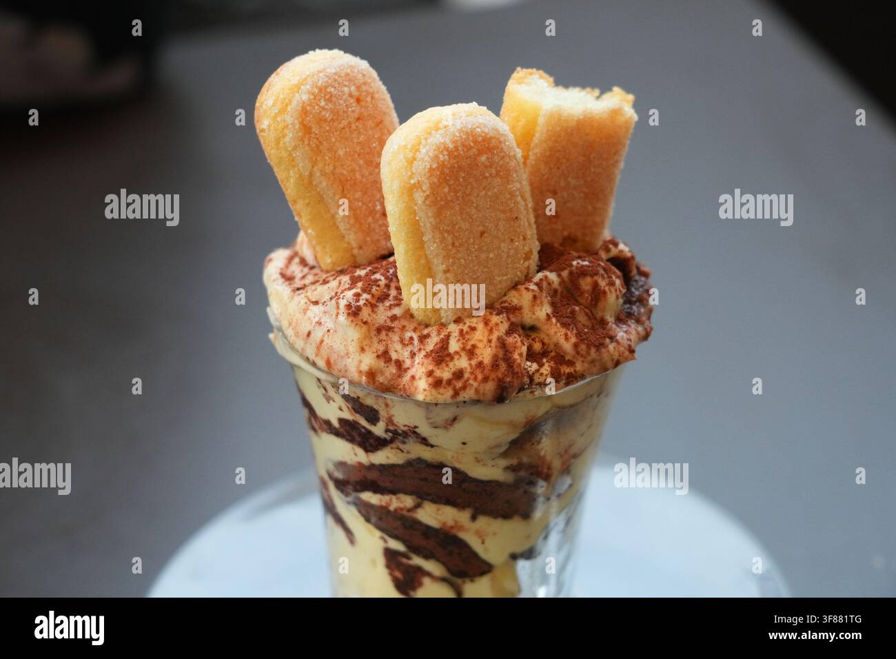 Variante di dessert italiano Tiramisu servito in un bicchiere. Il Tiramisu è fatto con biscotti savoiardi, mascarpone e uova. È aromatizzato al caffè Foto Stock