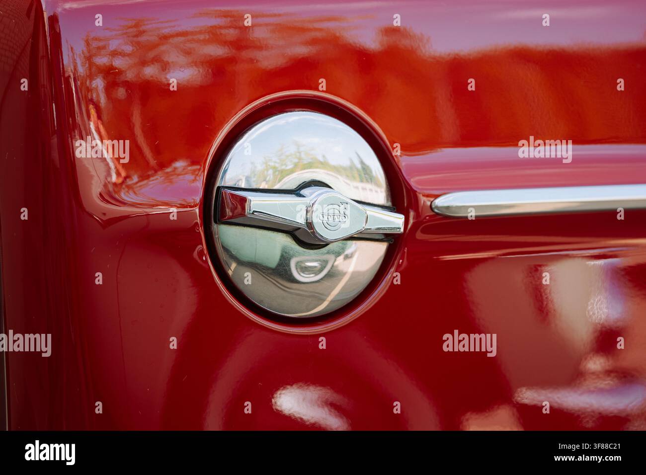 Lindau, Svizzera, 9 agosto 2026. Primo piano dettagliato di un tappo del serbatoio rotondo in cromo con maniglia con emblema Volvo, inserito nella carrozzeria dipinta di rosso di un cl Foto Stock