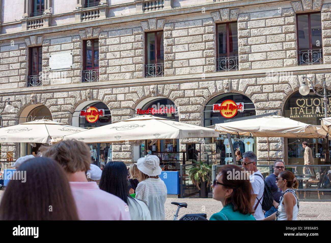 Vista esterna dell'edificio del Hard Rock Cafe con posti a sedere all'aperto nel centro storico. Insegna del logo sulla parete d'ingresso. Milano, Italia - 24 giugno 2026 Foto Stock