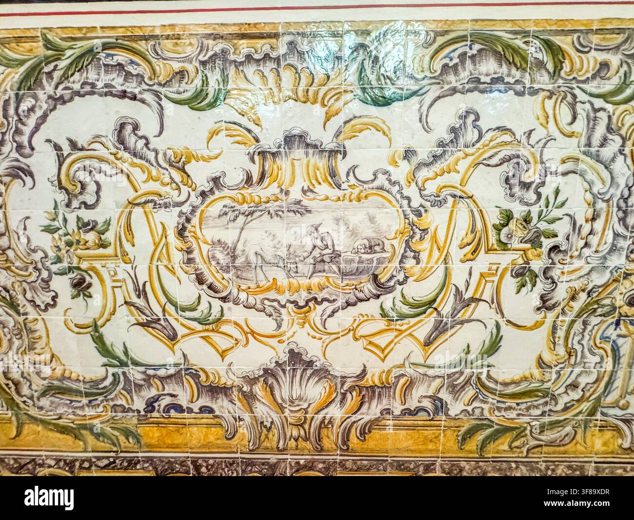 Affresco a piastrelle antiche con decorazioni a volute e scena centrale. Motivi decorativi nei toni del giallo, verde e grigio. Disegno con elementi floreali e simili a vite Foto Stock