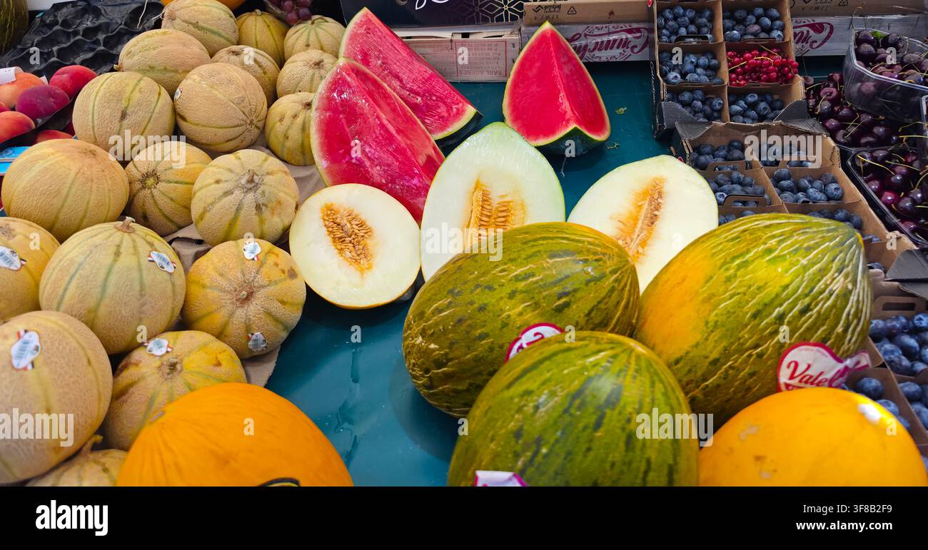 Meloni freschi di stagione e frutti estivi su un banco del mercato. Foto Stock