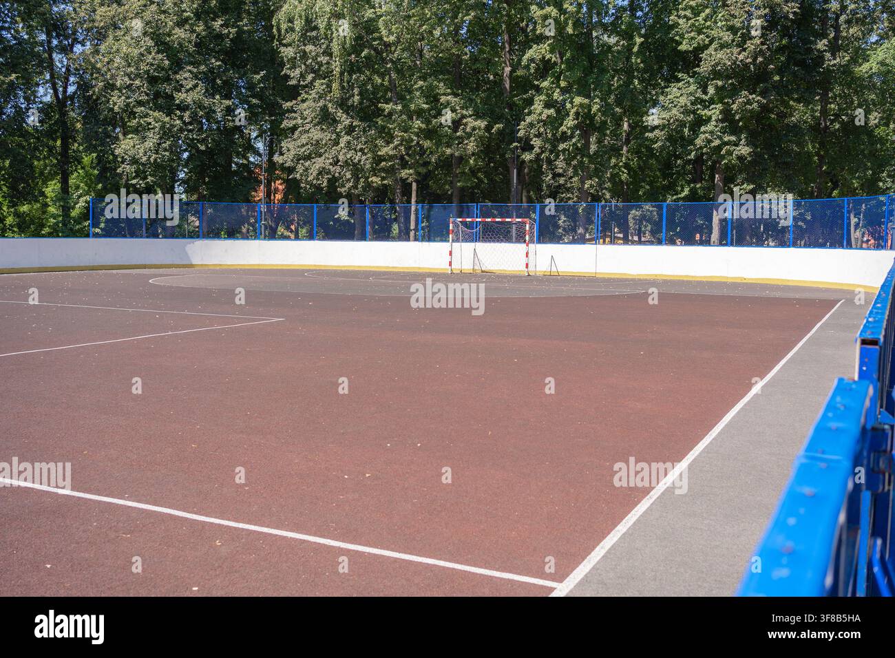 Campo sportivo pubblico all'aperto attrezzato per partite di calcio e basket in una luminosa giornata estiva. Sfondo perfetto per l'educazione fisica, la scuola Foto Stock