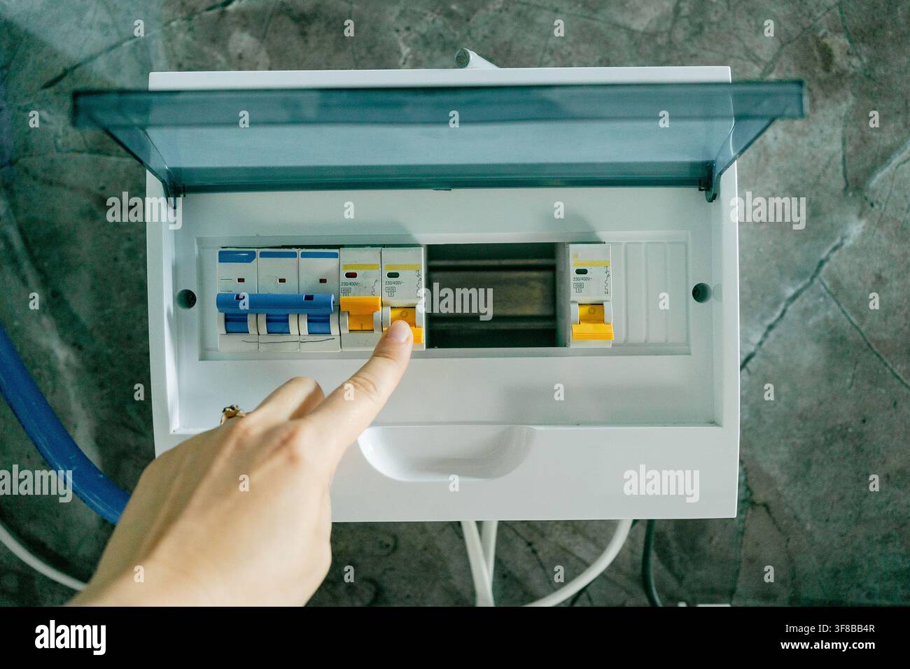 Vista ravvicinata di una persona che aziona un interruttore in un pannello di controllo elettrico. Immagine stock perfetta per il lavoro degli elettricisti, la gestione della rete elettrica Foto Stock
