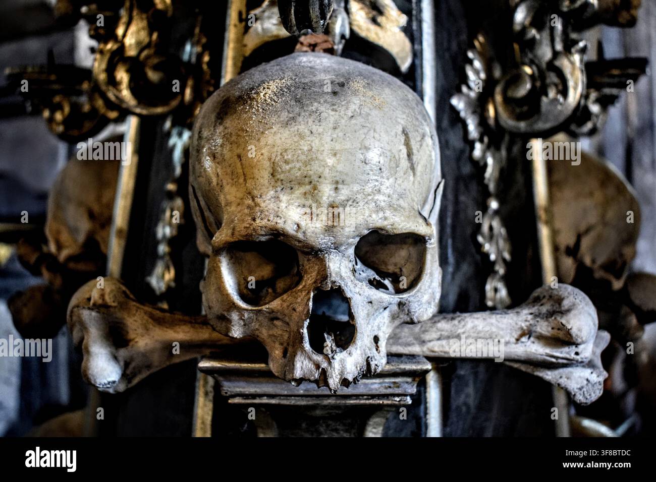 Primo piano di una decorazione a teschio e ossa incrociate in un ossario di chiesa Foto Stock