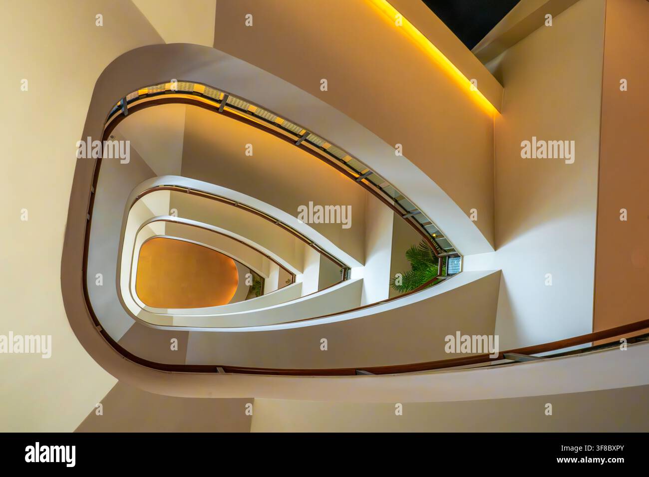Vista dell'elegante scala a chiocciola all'interno del The Peninsula Tokyo, con curve architettoniche moderne, illuminazione calda e design minimalista a Chiyod Foto Stock