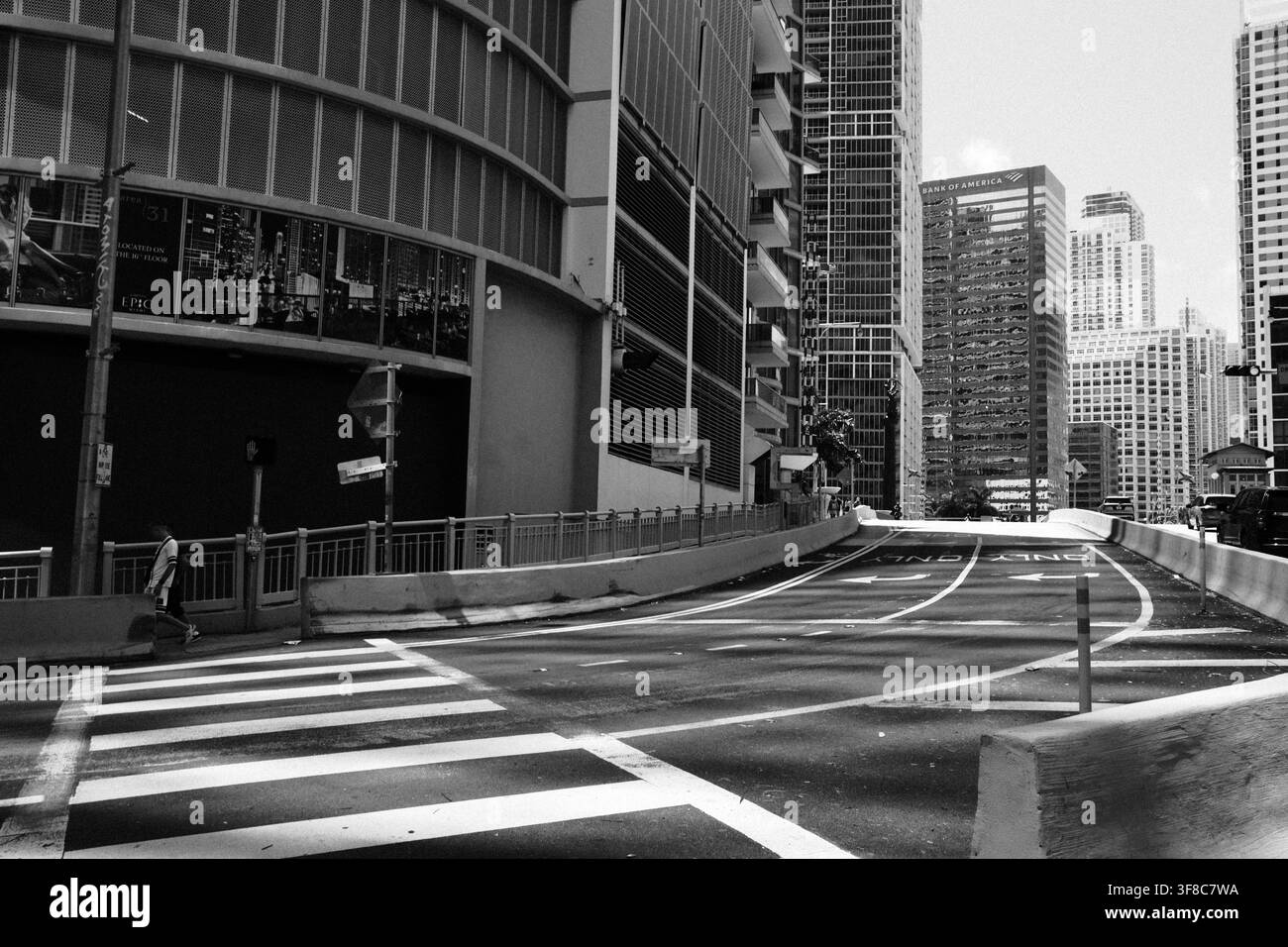 Strada urbana deserta che si snoda tra grattacieli moderni e torri di uffici, fotografata in bianco e nero. Foto Stock