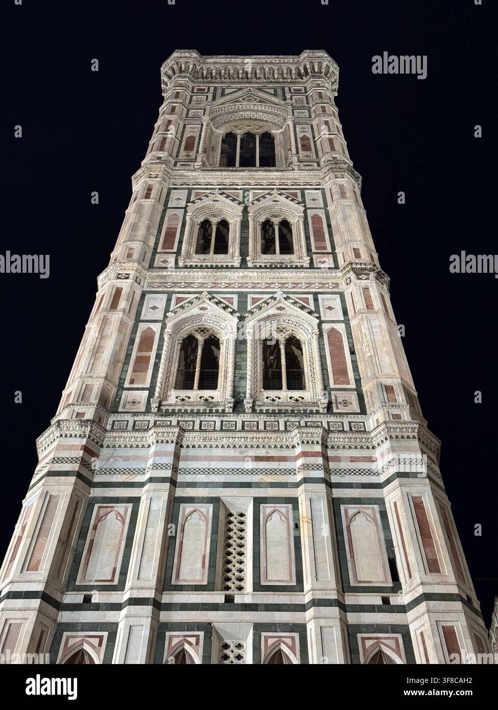 Il campanile della Cattedrale di Firenze si erge alto nel cielo notturno. Il campanile presenta disegni e motivi intricati. Foto Stock