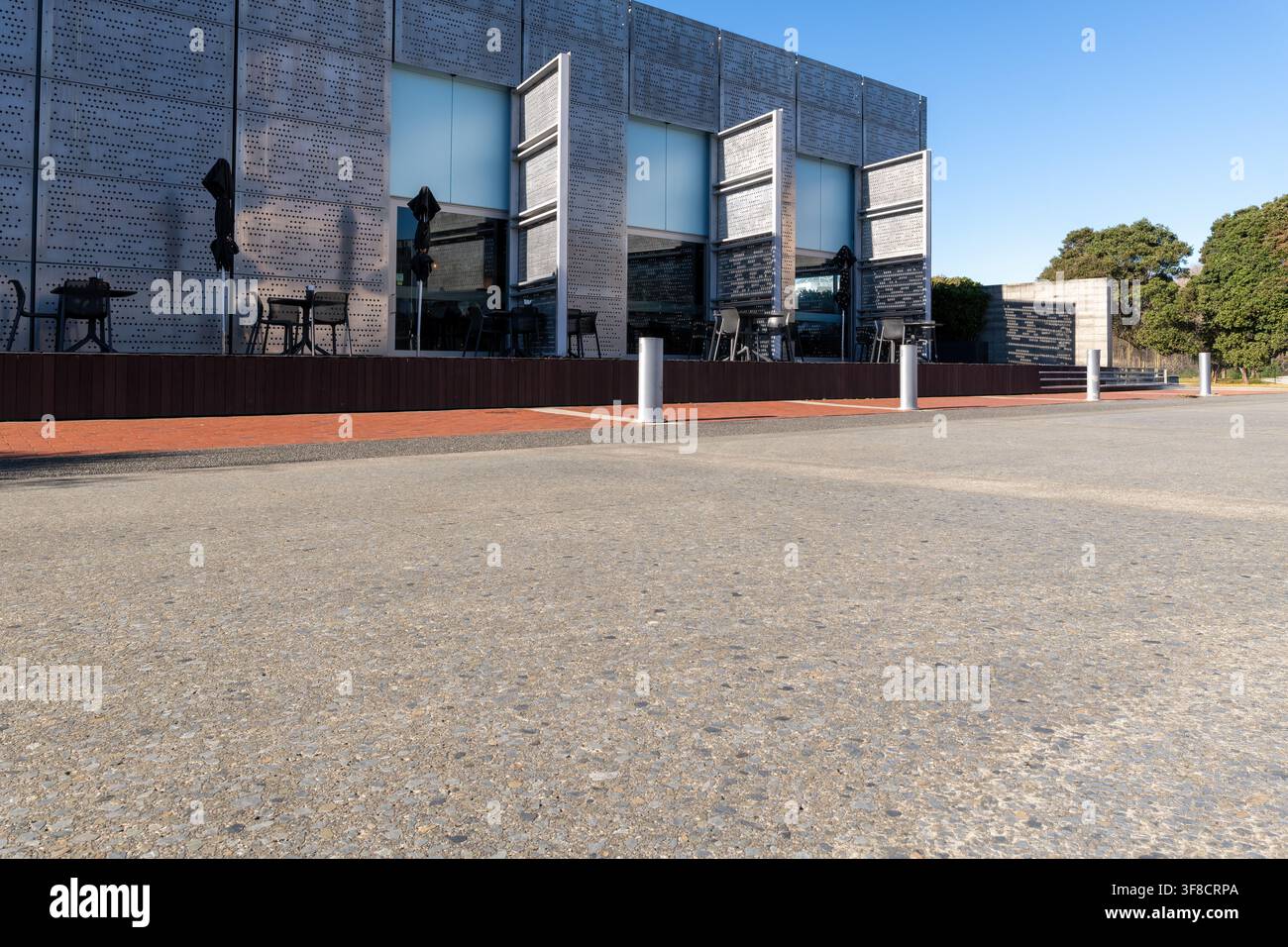 Strada, sfondo di auto, piastra posteriore automobilistica, area di parcheggio fuori da un caffè con architettura moderna Foto Stock