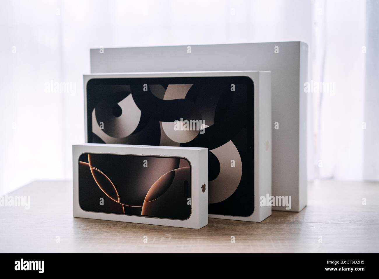 Le scatole di Apple iPhone e iPad sono posate su un tavolo di legno. Confronto della gamma di prodotti Apple, dimensioni iPhone iPad MacBook, visualizzazione della famiglia di dispositivi Apple. Varsavia Foto Stock