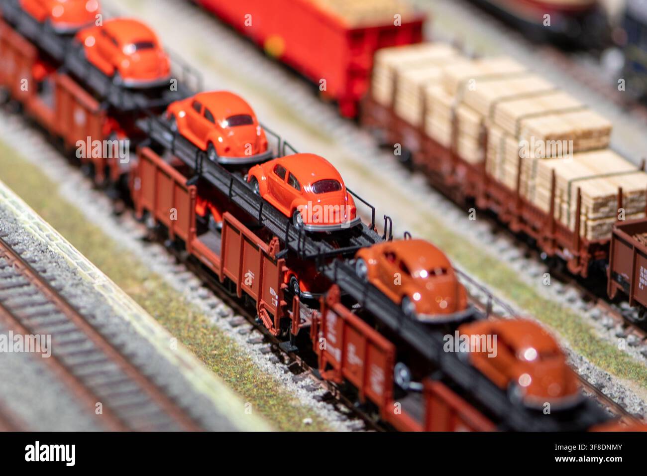 VIENNA, AUSTRIA, 26 novembre 2022: Vista ravvicinata di un treno merci in scala che trasporta piccole auto giocattolo arancioni su carri piani accanto a un altro Foto Stock