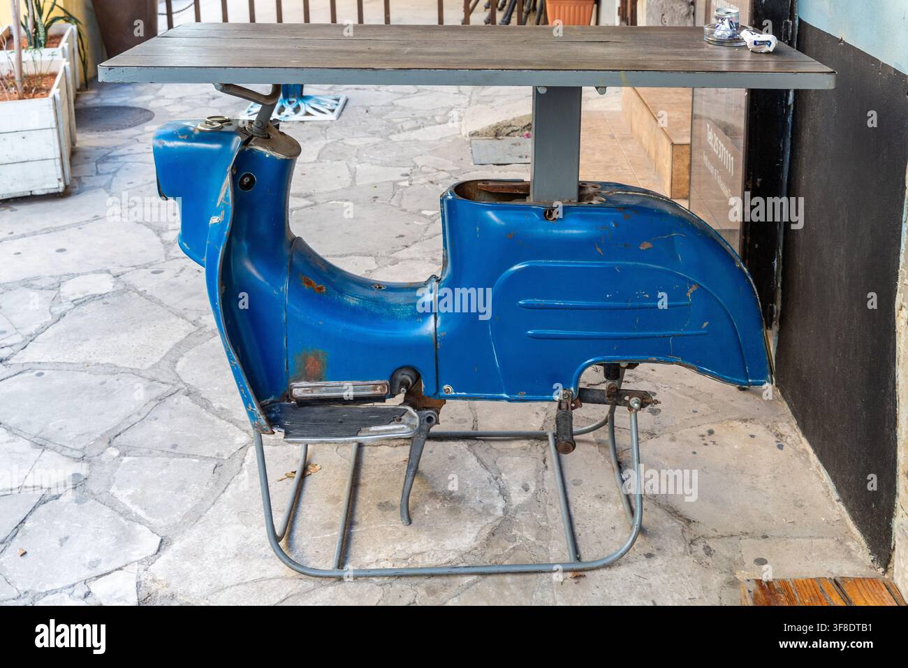 In una strada di Limassol, un bar ha costruito i propri tavoli incorporando la carrozzeria di un motorino tipo Vespa. Foto Stock
