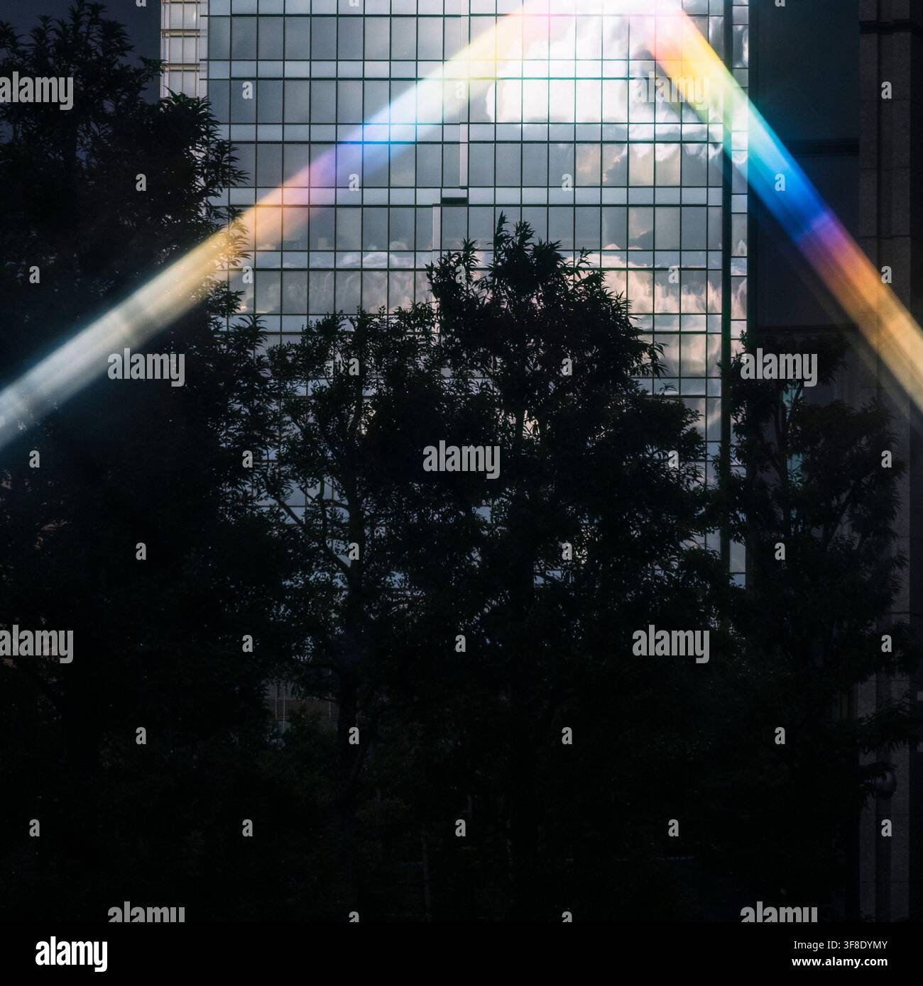 Riflessione della luce arcobaleno su un edificio di uffici moderno in vetro Foto Stock