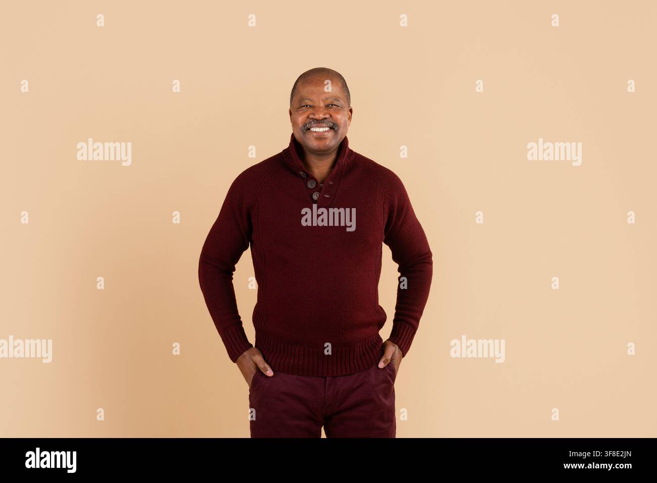 Uomo afroamericano maturo sorridente in piedi con sicurezza con le mani in tasca Foto Stock