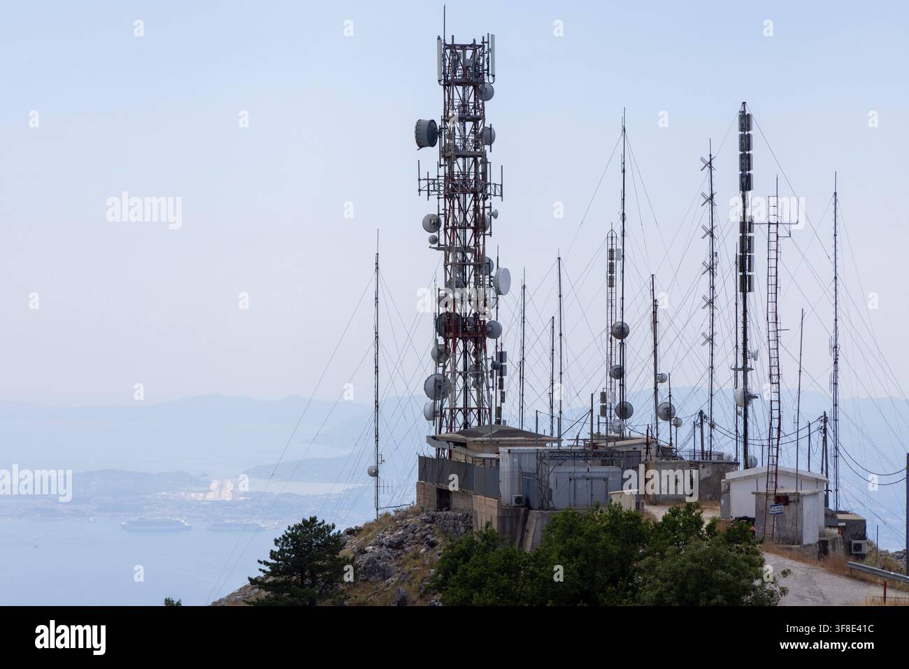 Complesso di torri e antenne di telecomunicazione che occupano la cima di una montagna, fornendo una copertura di rete e una trasmissione del segnale estese Foto Stock