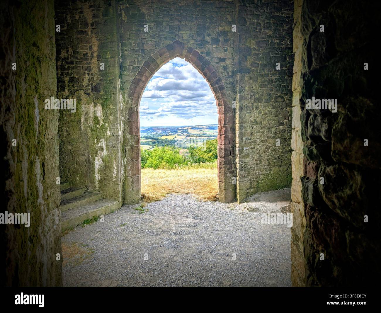Vista sulla campagna del Carmarthenshire attraverso un arco di pietra all'interno di Paxton's Tower vicino a Llanarthney, Galles occidentale, Regno Unito, agosto 2026. - Immagine stock catturata con smartphone