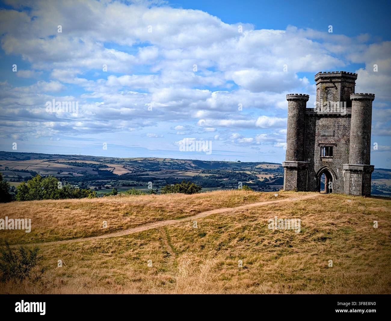 Paxton's Tower circondato da erba secca colpita dalla siccità, che si affaccia sulla campagna del Carmarthenshire vicino a Llanarthney, Galles occidentale, Regno Unito, durante l'estate - Immagine stock catturata con smartphone