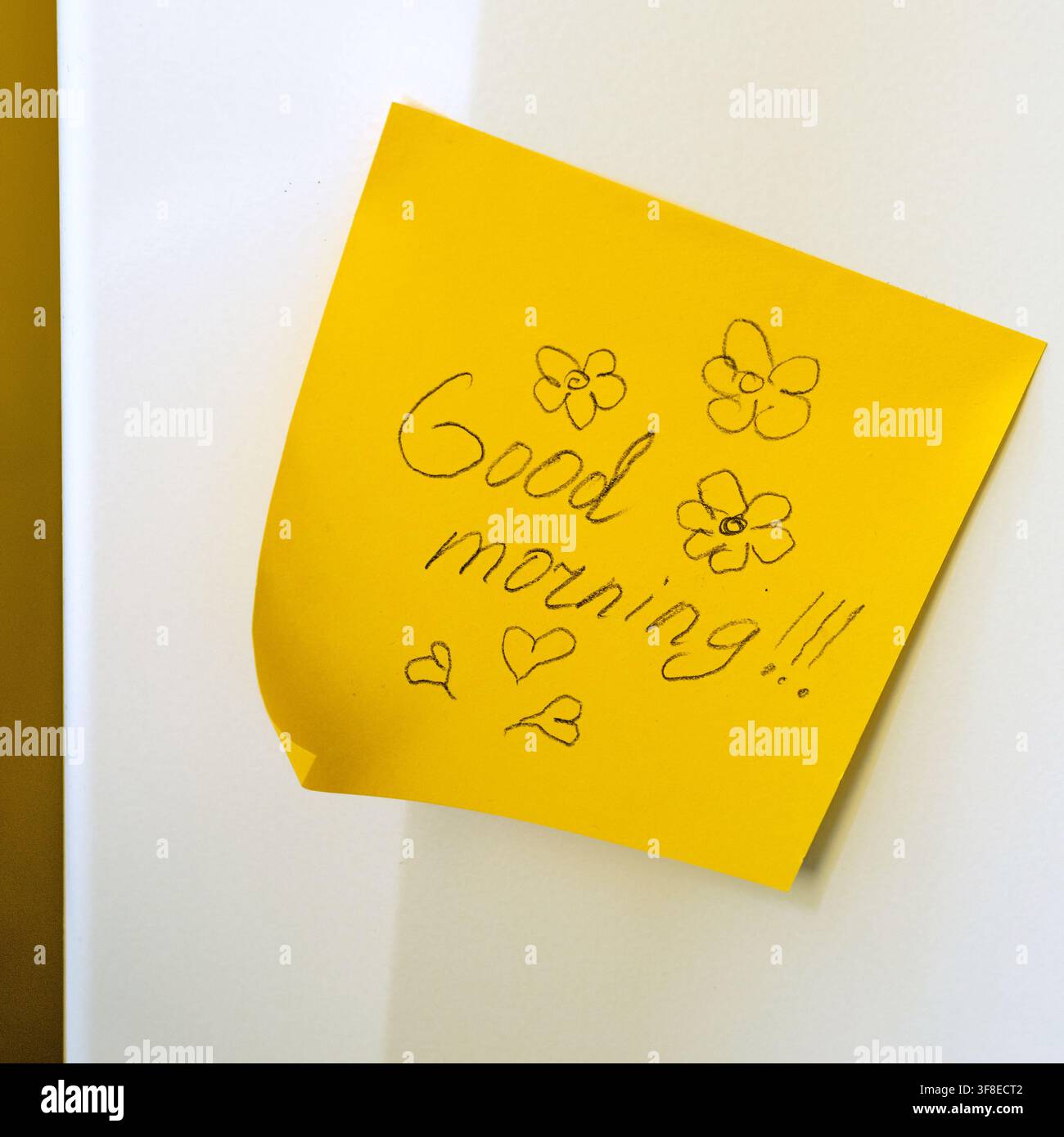 Post-it giallo con la scritta manoscritta “Buongiorno!!!” e scarabocchi – Un inizio allegro della giornata Foto Stock