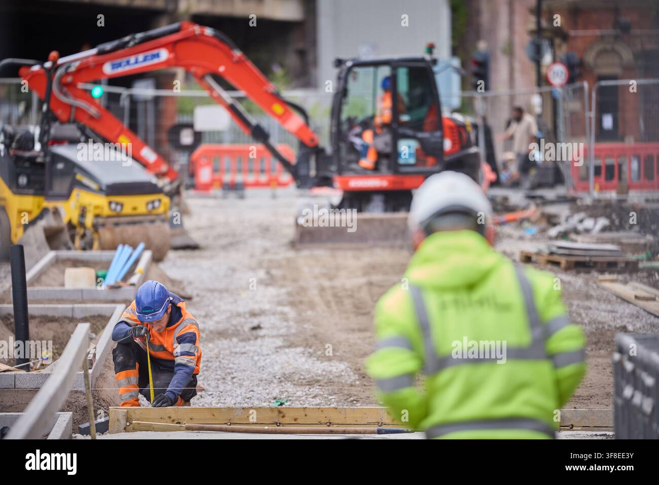 Posizione di pavimentazioni in un spazio pubblico a Manchester, lavori eseguiti da appaltatori Foto Stock