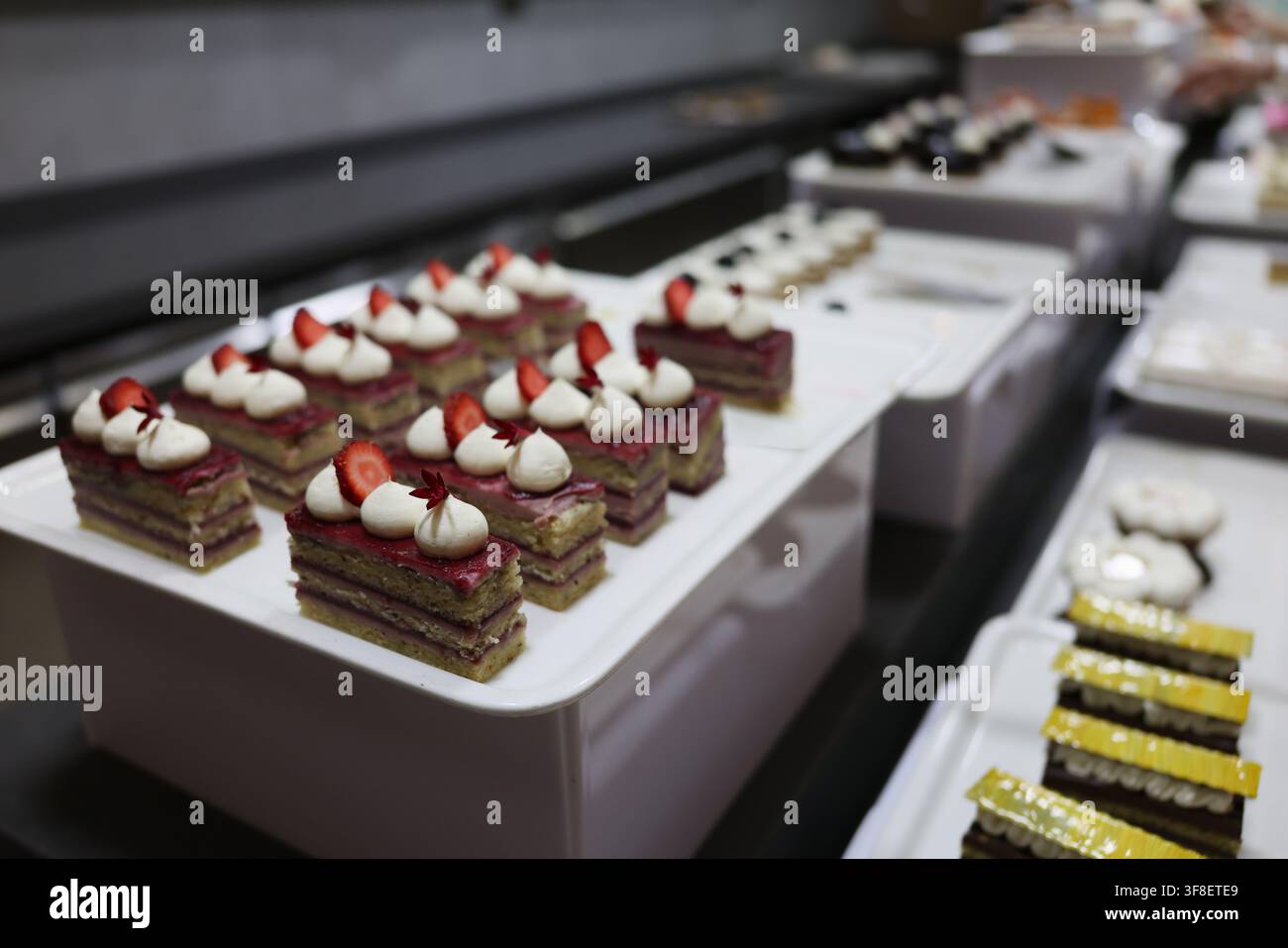 Dolci deliziosi in attesa di ammirare le papille gustative in una cucina di panetteria vivace Foto Stock