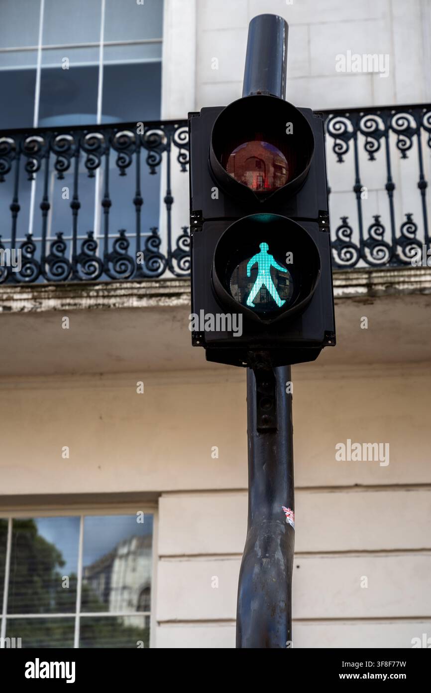 Segnale stradale pedonale verde illuminato su un semaforo davanti all'architettura tradizionale di York, Inghilterra Foto Stock