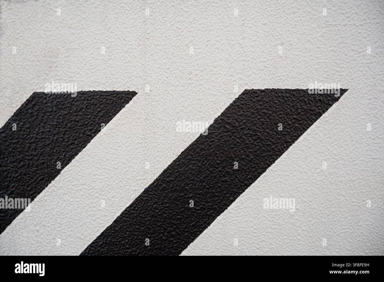 Strisce diagonali nere dipinte su uno sfondo di muro in cemento bianco texture. Foto Stock