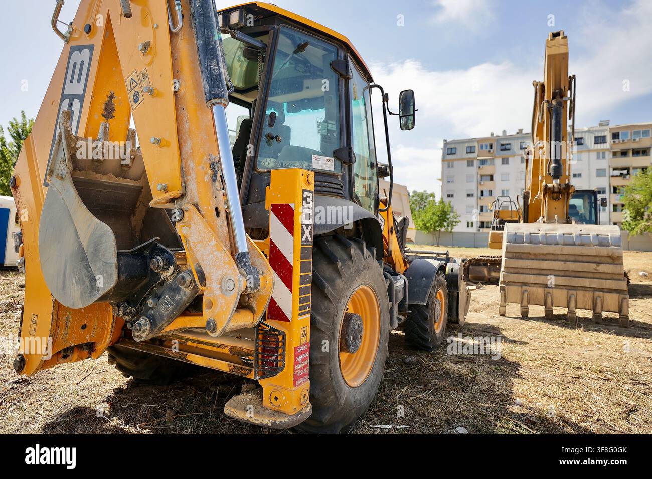 Caricatore-pala JCB 3CX ed escavatore in un cantiere edile urbano Foto Stock